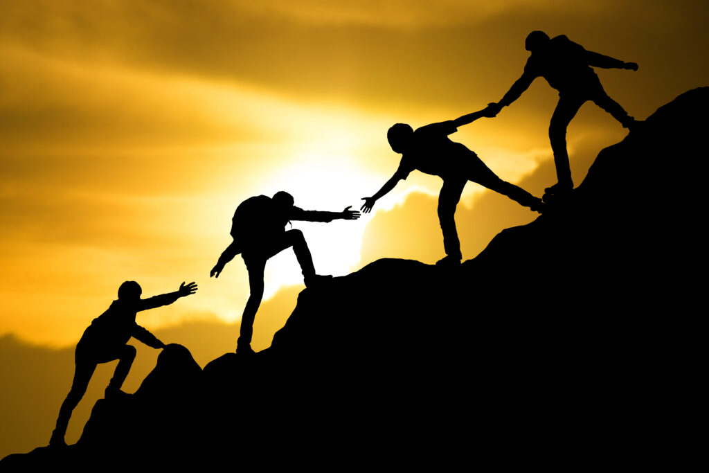 People helping others up mountain
