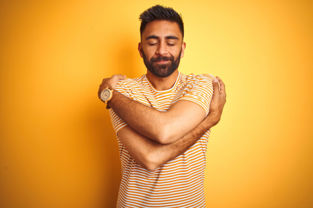 Man hugging self