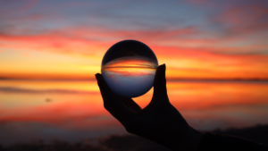 Image of a sunset in a ball held in a hand