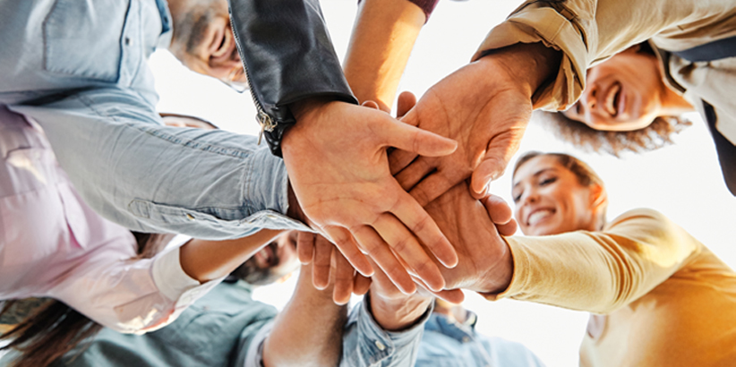 Group of people in a circle holding hands in the center