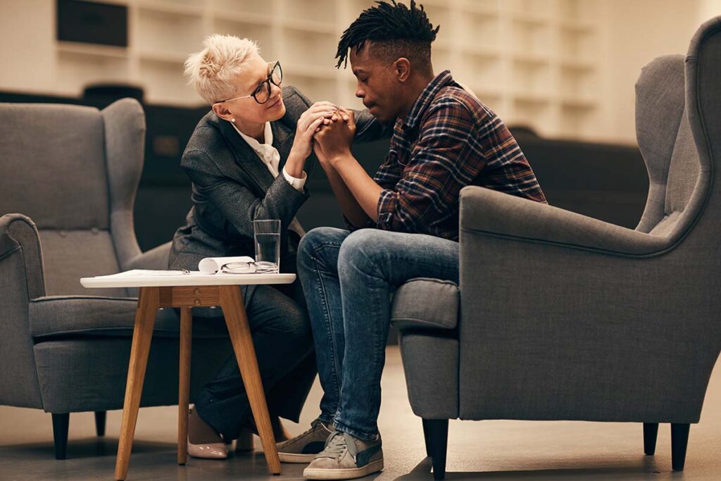 Elderly woman comforting a young man