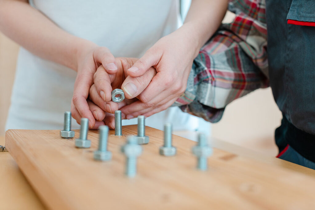 Therapist helping someone place a nut on screw