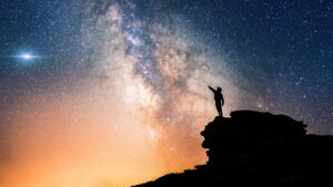 Person pointing at galaxies