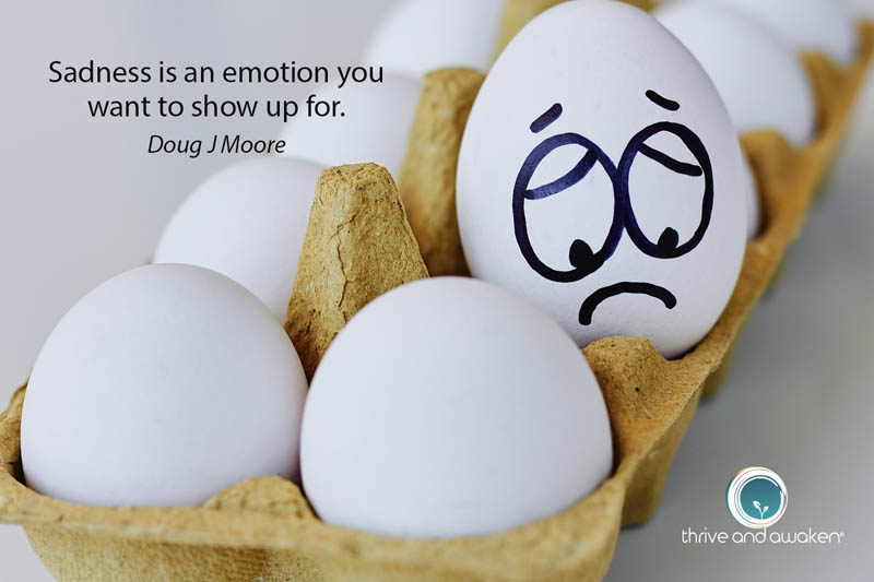 A dozen eggs, one with a sad face. Quote from Doug: Sadness is an emotion you want to show up for