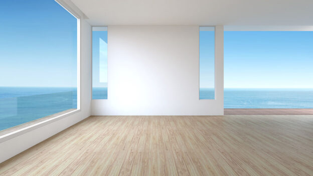 Looking out of a home with glass walls onto a sea