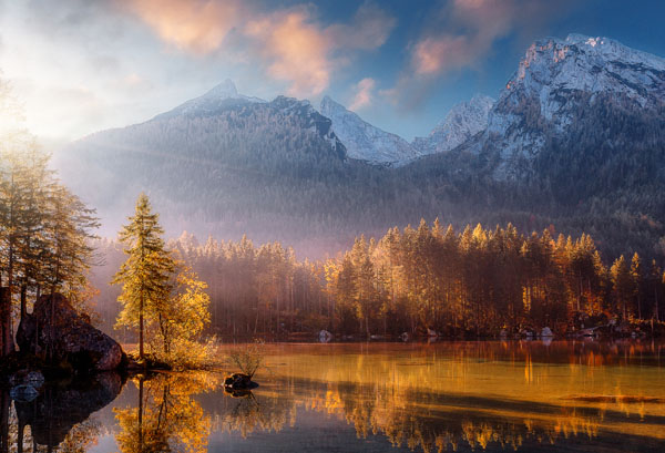 Sunset behind mountains with a lake in front