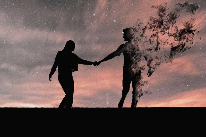 Two people holding hands, one of them fading away